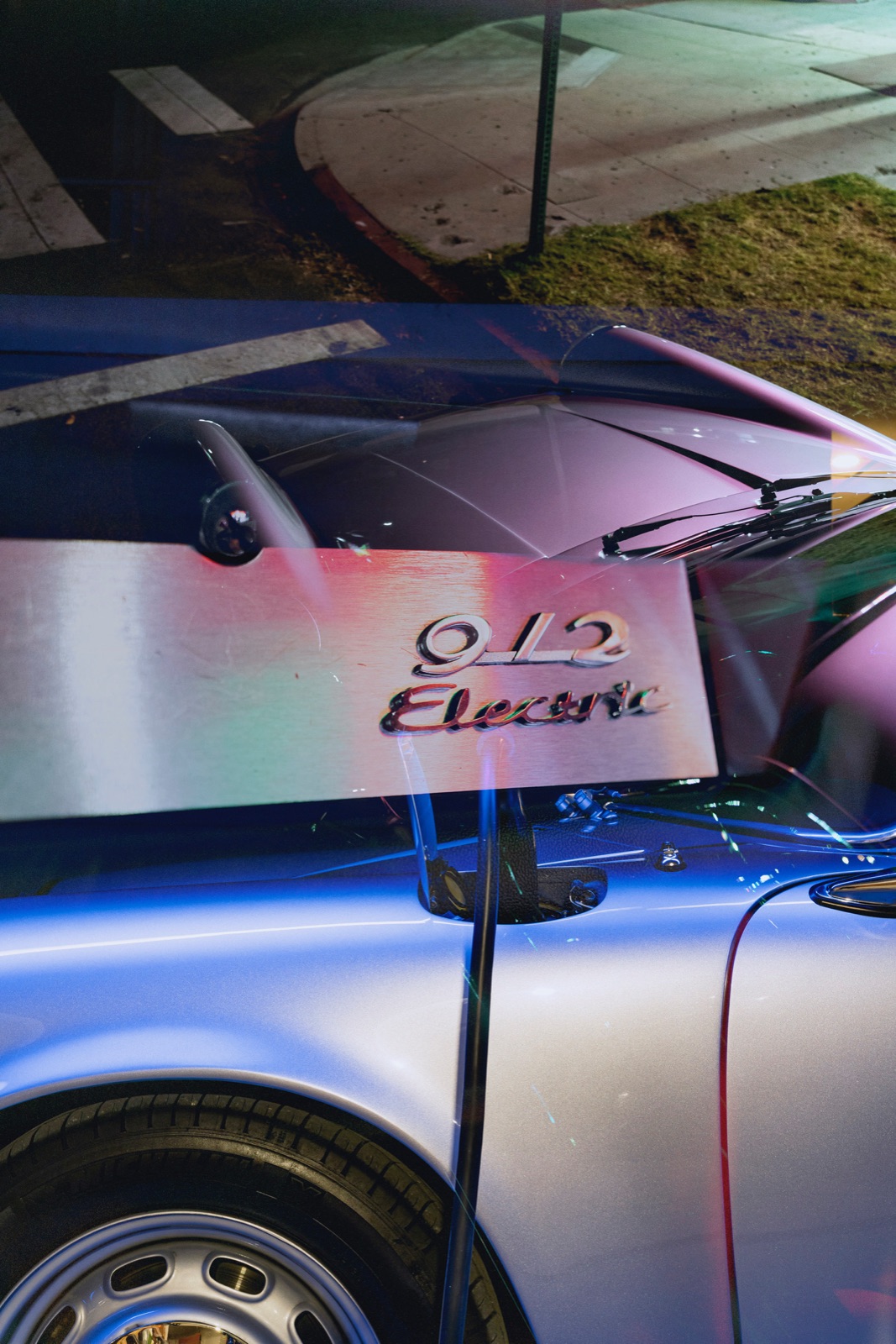 The &lsquo;912 Electric&rsquo; badge glowing under neon at night