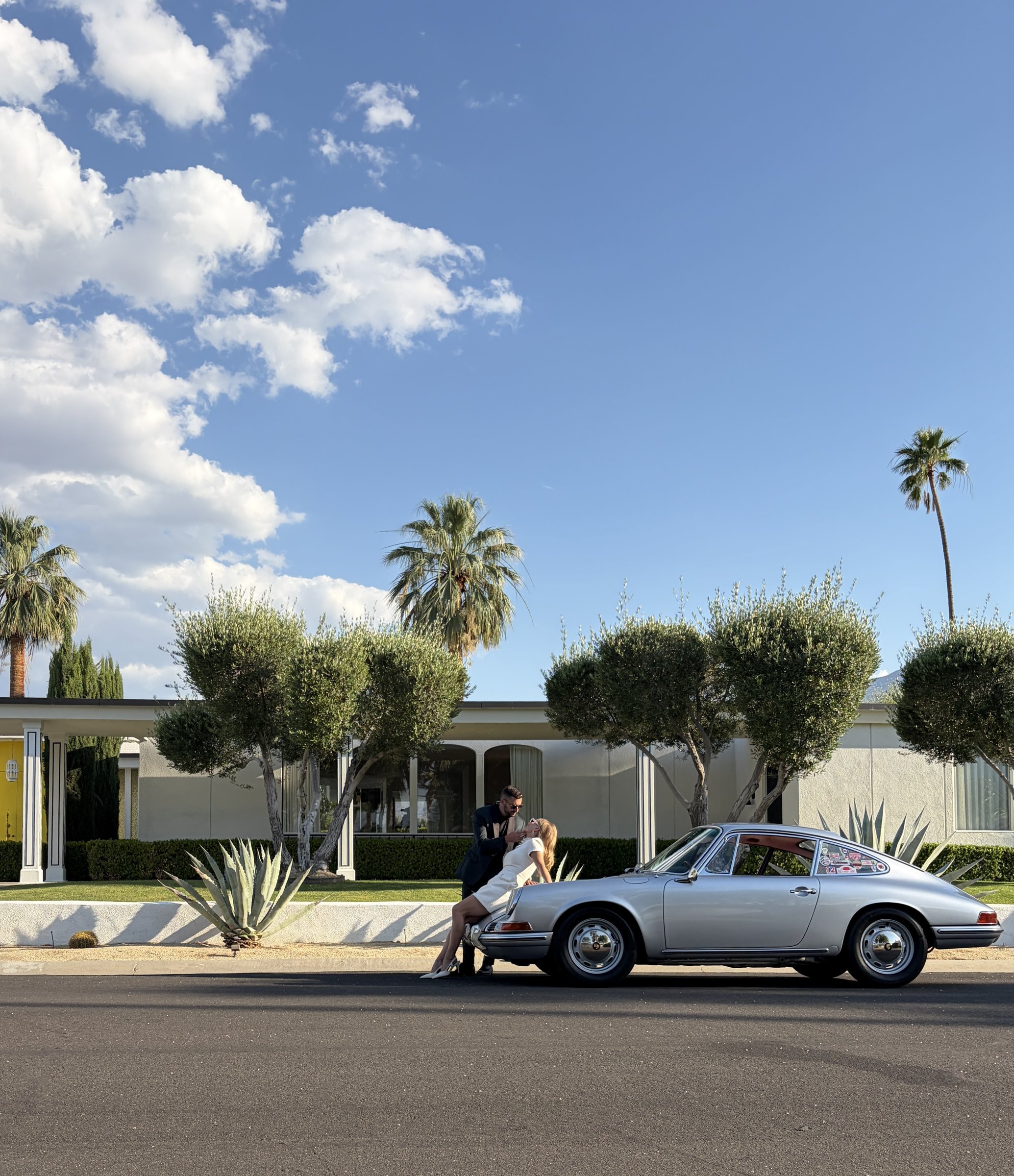 A wedding couple with the ElectroPorsche outside a Palm Springs mid-century modern home